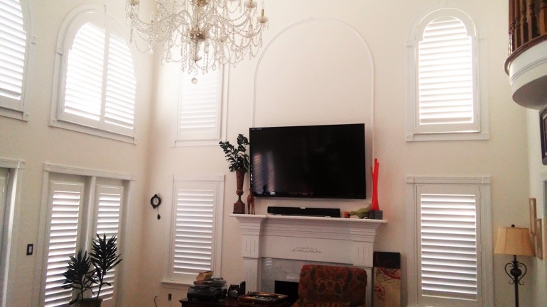 Charlotte great room with mounted television and arched windows.